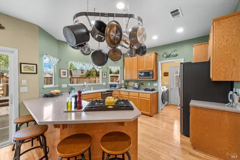 a kitchen with stainless steel appliances granite countertop a sink a stove and a wooden floors