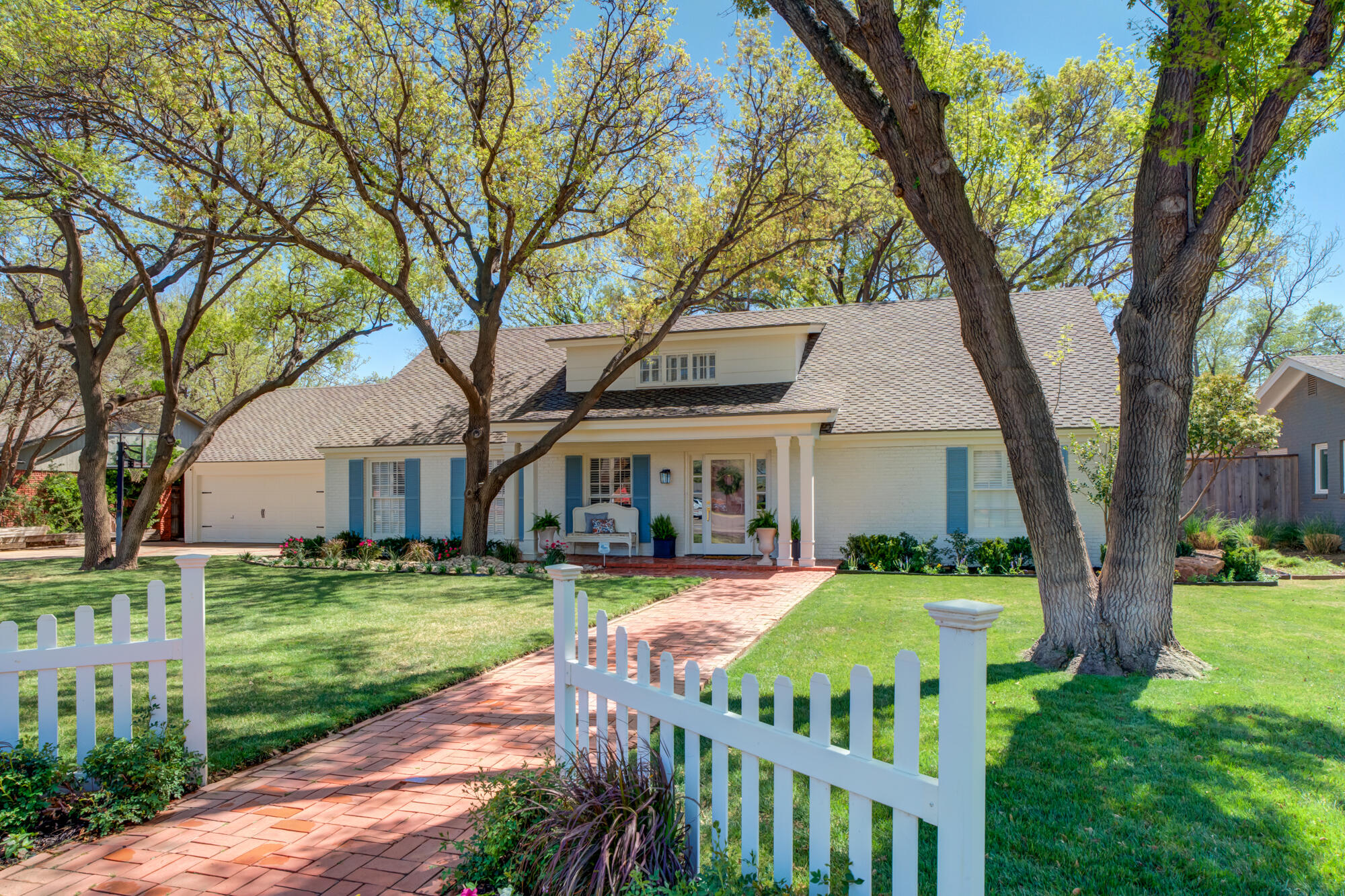a view of a house with a yard deck and a large tree