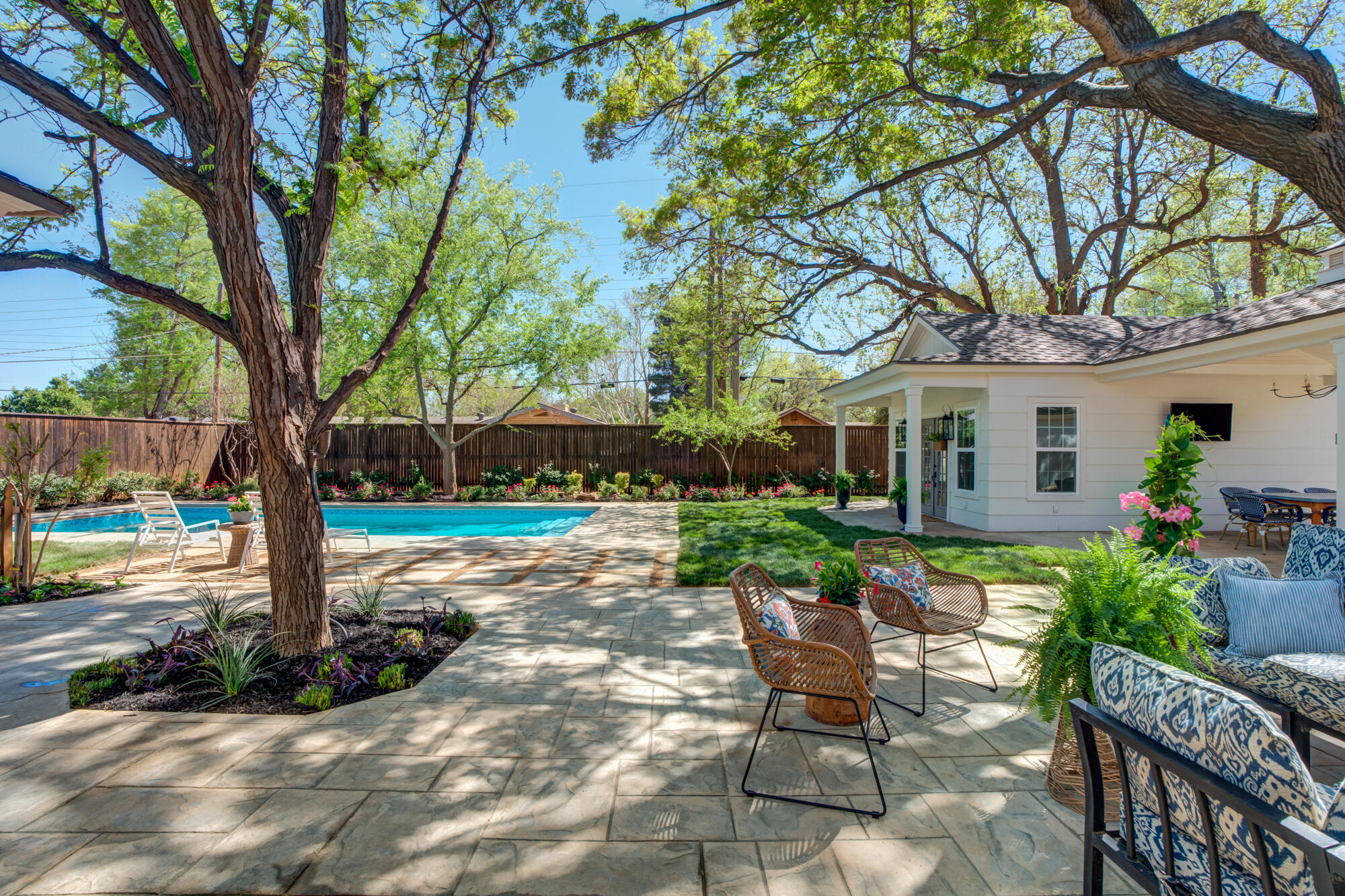 4407 13th Street Lubbock, TX 79416 - Photo 66 of 88 a view of a patio with table and chairs potted plants and large tree
