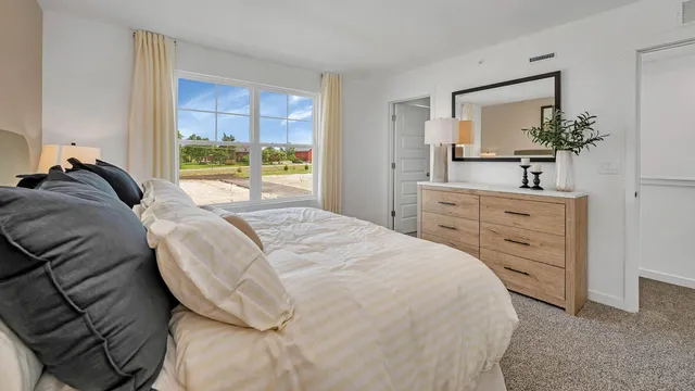 a spacious bedroom with a bed and a dresser