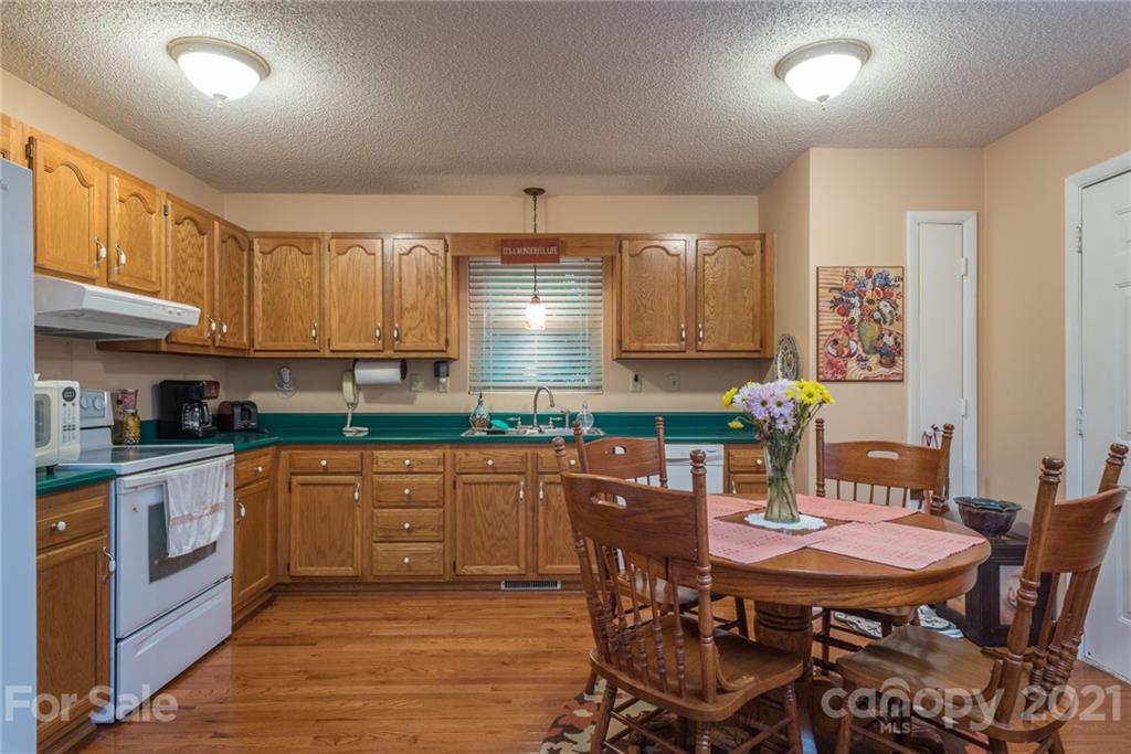 31 Bear Trail Fairview, NC 28730 - Photo 11 of 48 a kitchen with stainless steel appliances granite countertop a stove top oven a sink dishwasher white cabinets and a chairs