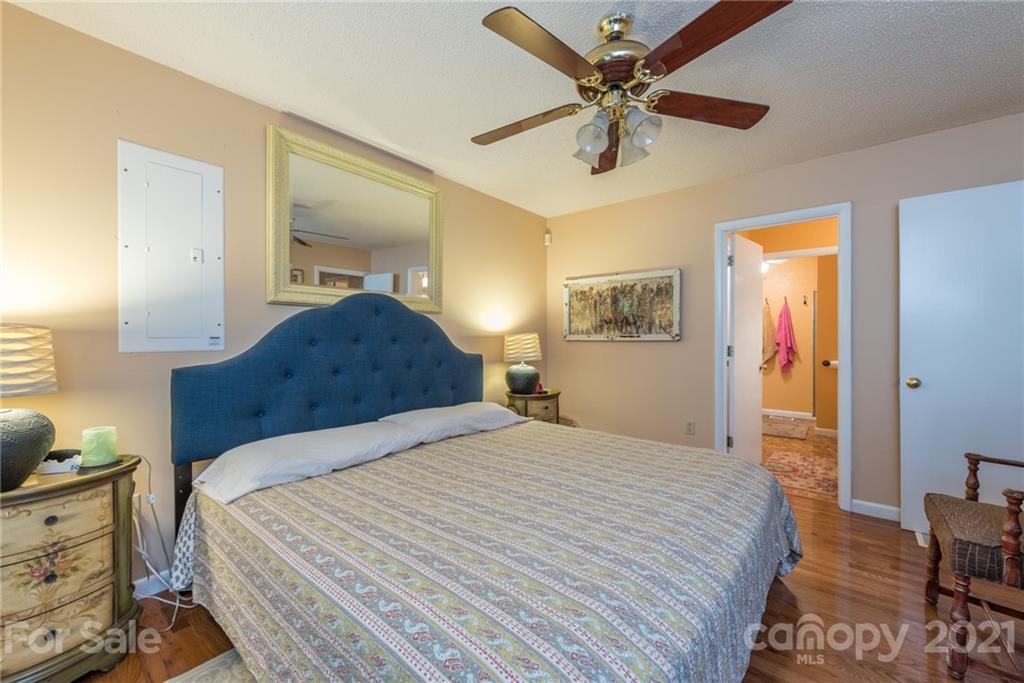 31 Bear Trail Fairview, NC 28730 - Photo 18 of 48 a bedroom with a bed and a chandelier