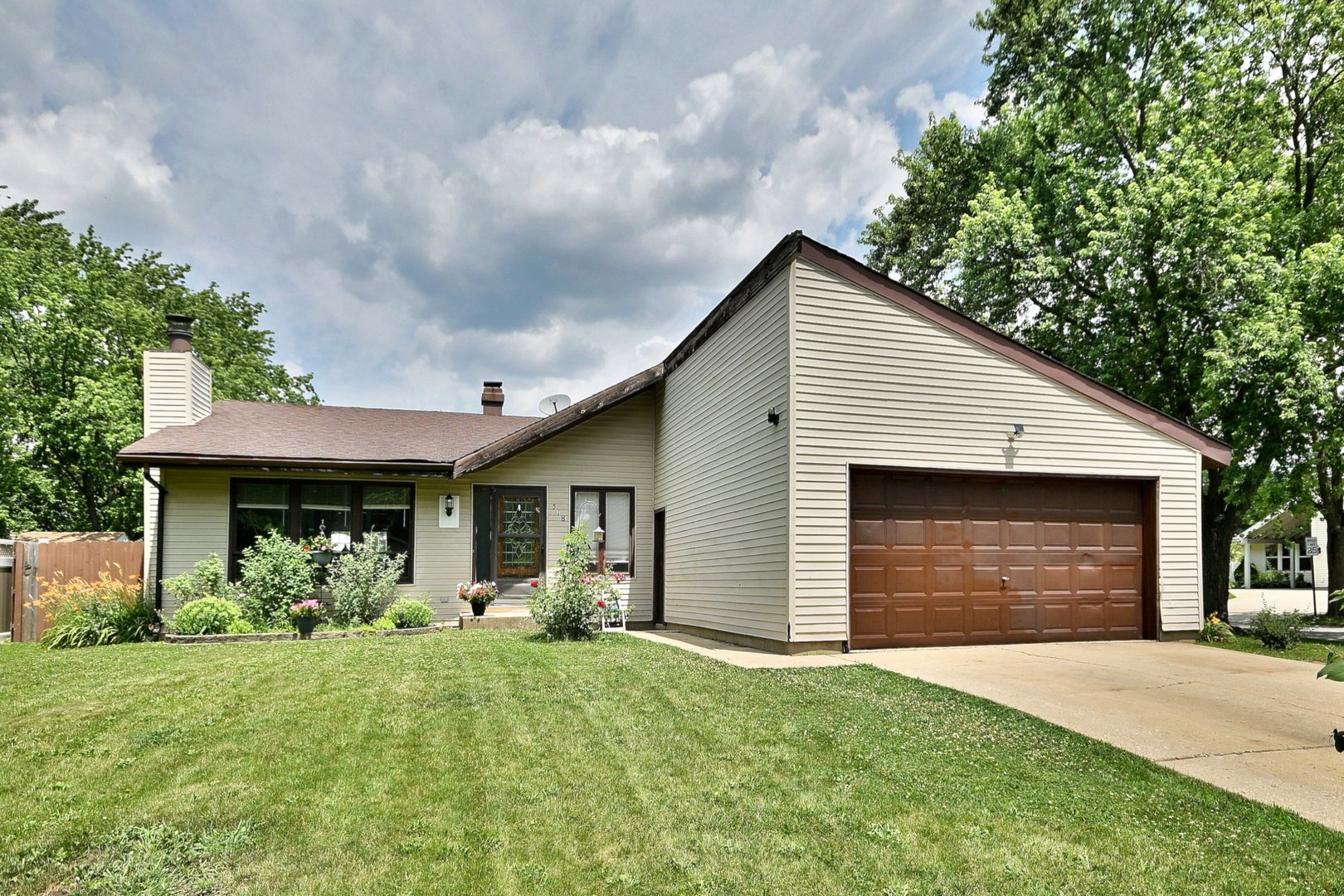 a front view of house with yard and trees in the background