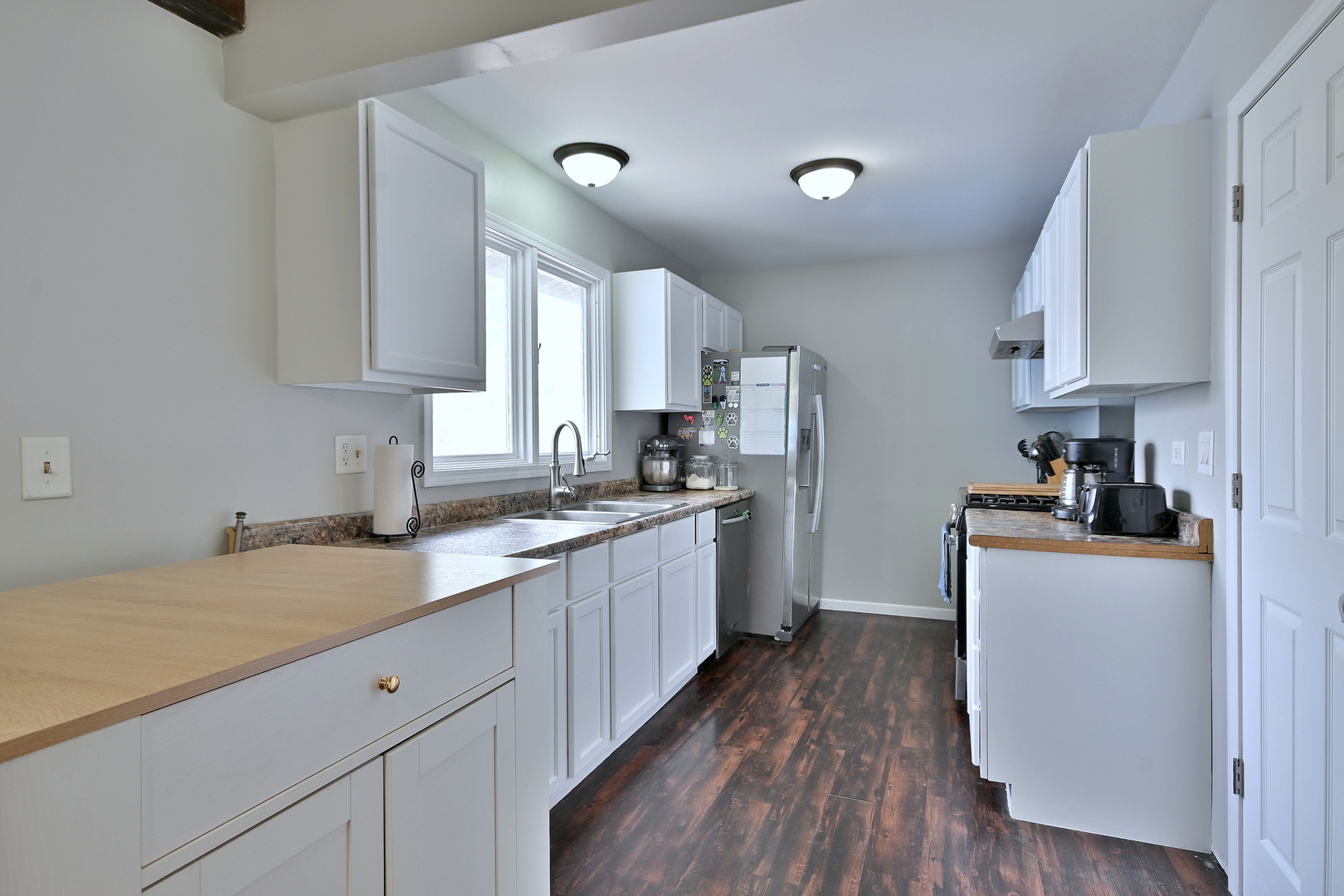 518 Emerson Circle Bolingbrook, IL 60440 - Photo 12 of 29 a kitchen with granite countertop a sink dishwasher stove and white cabinets with wooden floor