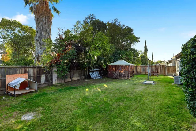 a backyard of a house with table and chairs a barbeque
