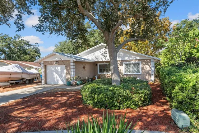 a front view of a house with a yard and potted plants
