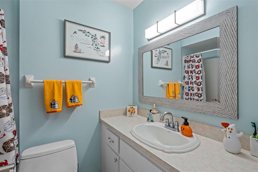 5558 57th Way Kenneth City, FL 33709 - Photo 17 of 33 a bathroom with a toilet sink and mirror