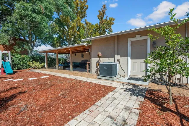 a view of a house with backyard and a tree
