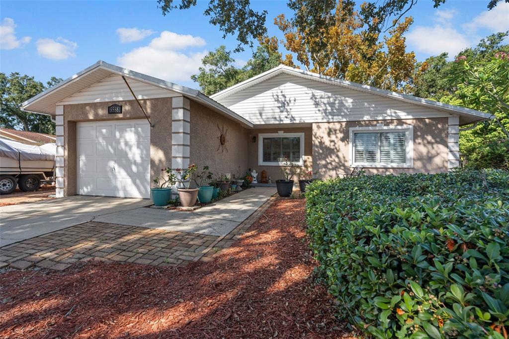 5558 57th Way Kenneth City, FL 33709 - Photo 27 of 33 a front view of a house with garden