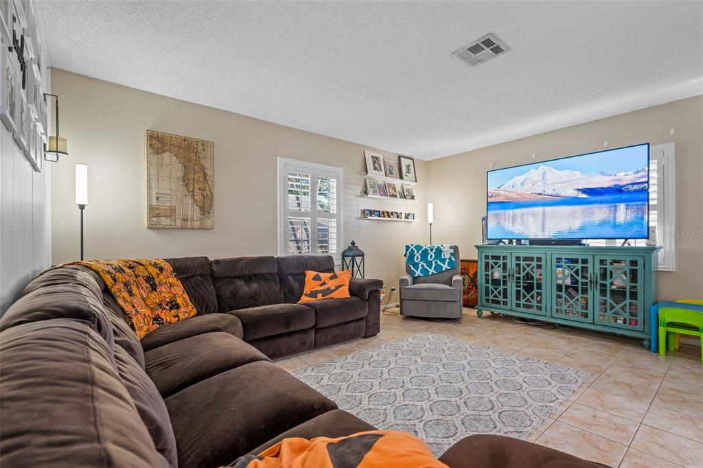 5558 57th Way Kenneth City, FL 33709 - Photo 4 of 33 a living room with furniture and a flat screen tv