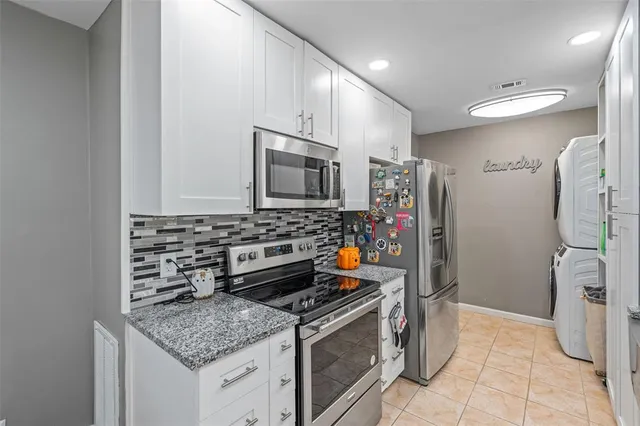 a kitchen with stainless steel appliances granite countertop a stove a refrigerator and a microwave