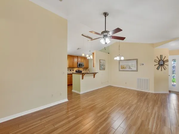 a view of a room with a wooden floor and a ceiling fan