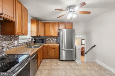 a hallway with a table and a refrigerator