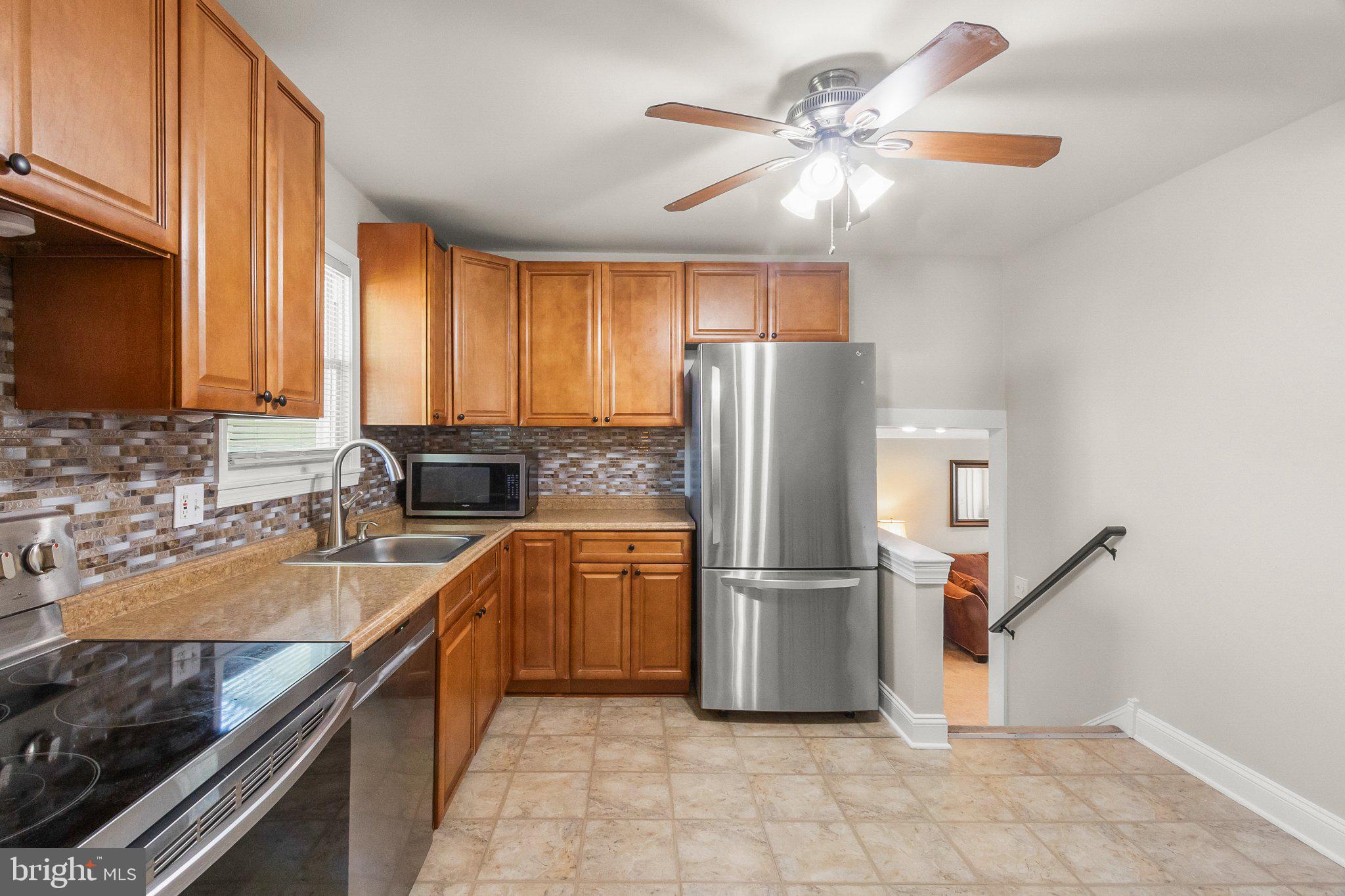 8 Slates End Newark, DE 19702 - Photo 25 of 54 a kitchen with granite countertop a refrigerator a sink a stove and cabinets