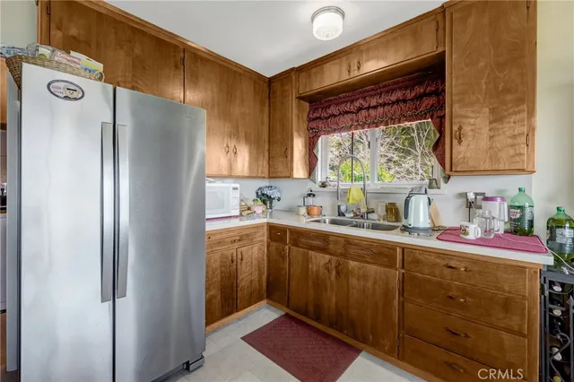 a kitchen with stainless steel appliances a sink a stove wooden floor cabinets and dining table