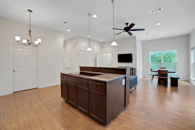 a living room with furniture large windows and wooden floor