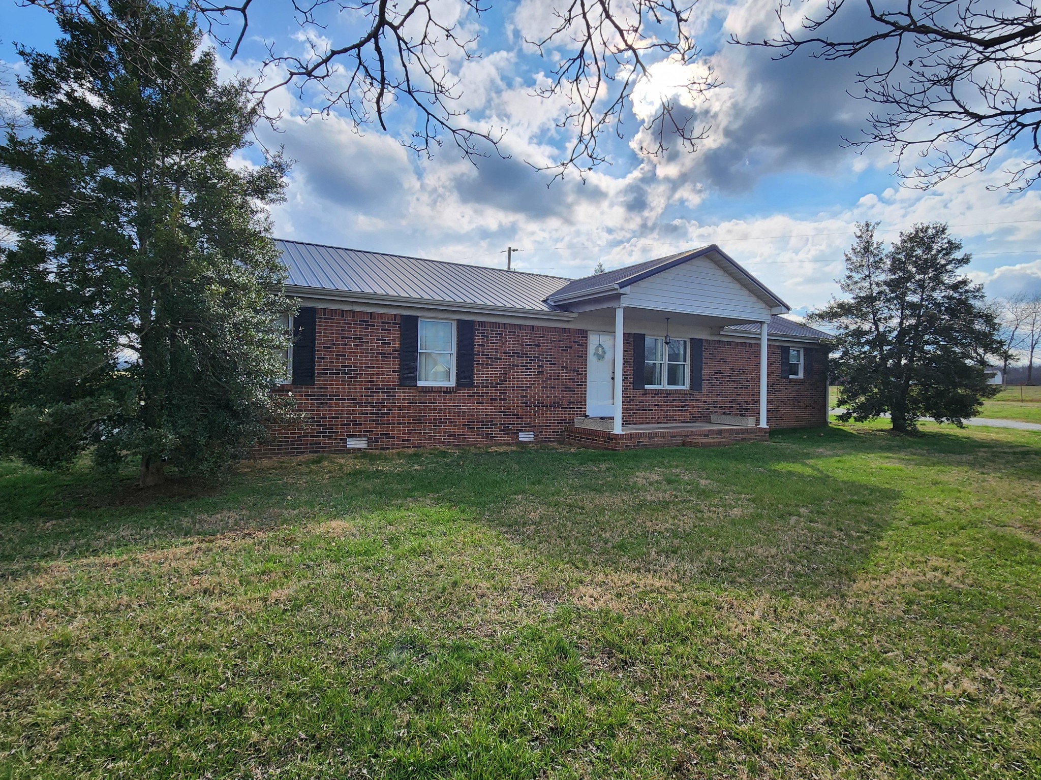 890 Tom Grissom Road Morrison, TN 37357 - Photo 1 of 17 a view of a brick house with a yard