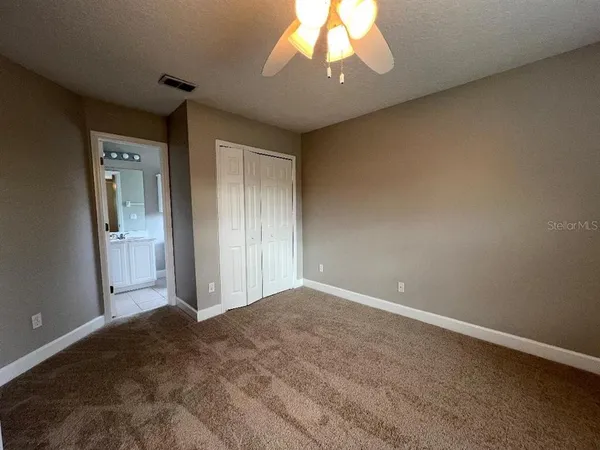 an empty room with a window and a fan