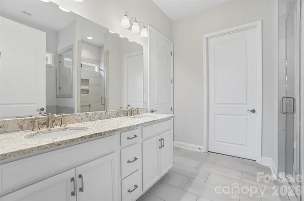 a bathroom with a granite countertop sink a large mirror and a shower