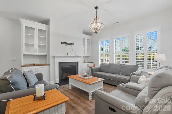 a living room with furniture a fireplace and a large window