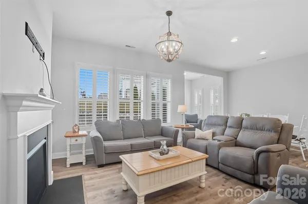 a living room with furniture a chandelier and a rug