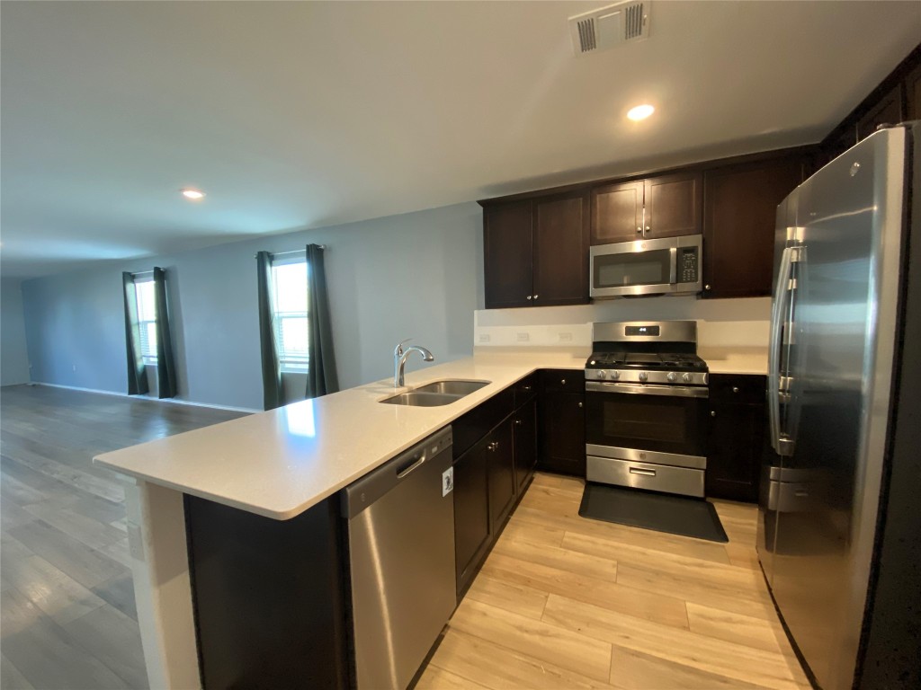 13704 Knights Branch Drive Elgin, TX 78621 - Photo 24 of 24 a kitchen with a sink and stainless steel appliances