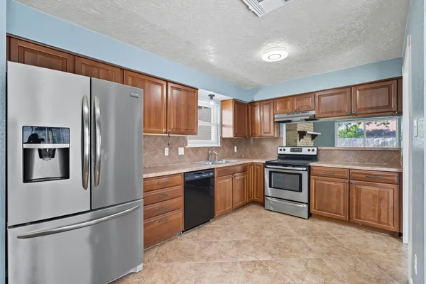 a kitchen with stainless steel appliances granite countertop a stove sink and cabinets