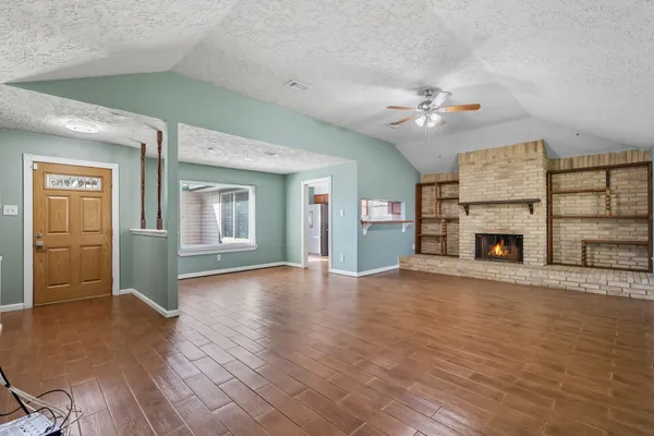 wooden floor fireplace and windows in an empty room