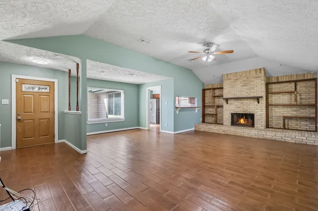 wooden floor fireplace and windows in an empty room