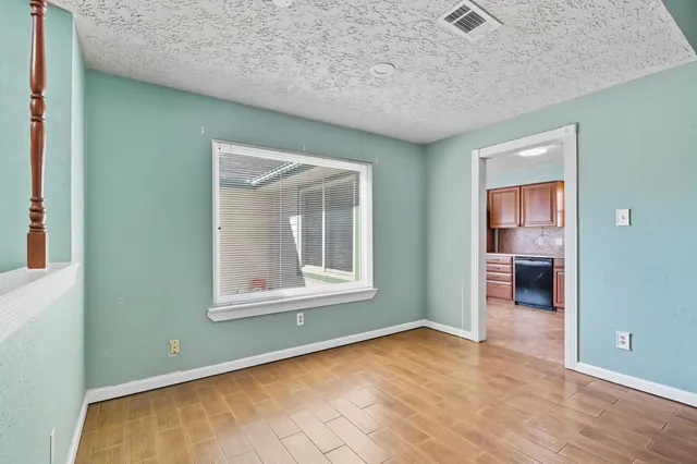 an empty room with wooden floor and a window