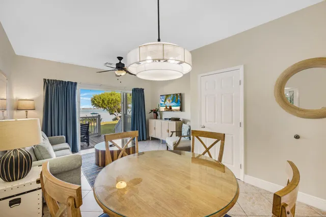 a living room with furniture kitchen view and a chandelier