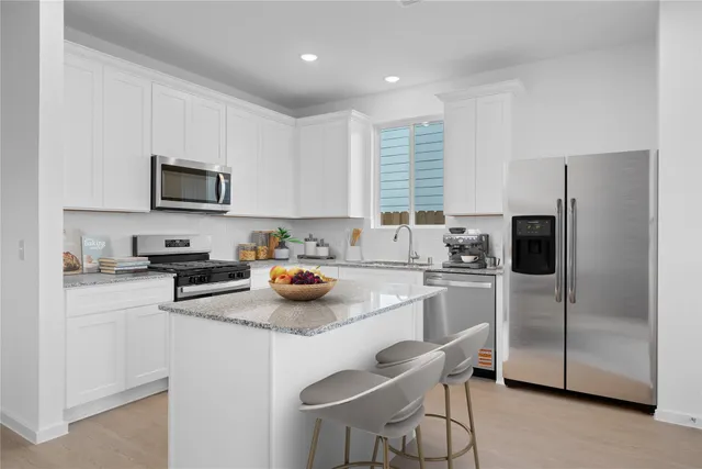 a kitchen with a refrigerator a stove a sink and a microwave