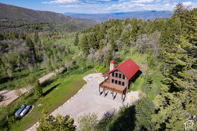 917 West Deep Forest Road Coalville, UT 84017 - Photo 39 of 41 Expansive mountain property featuring a log-sided residence with a red roof, a large exterior deck, and multiple windows