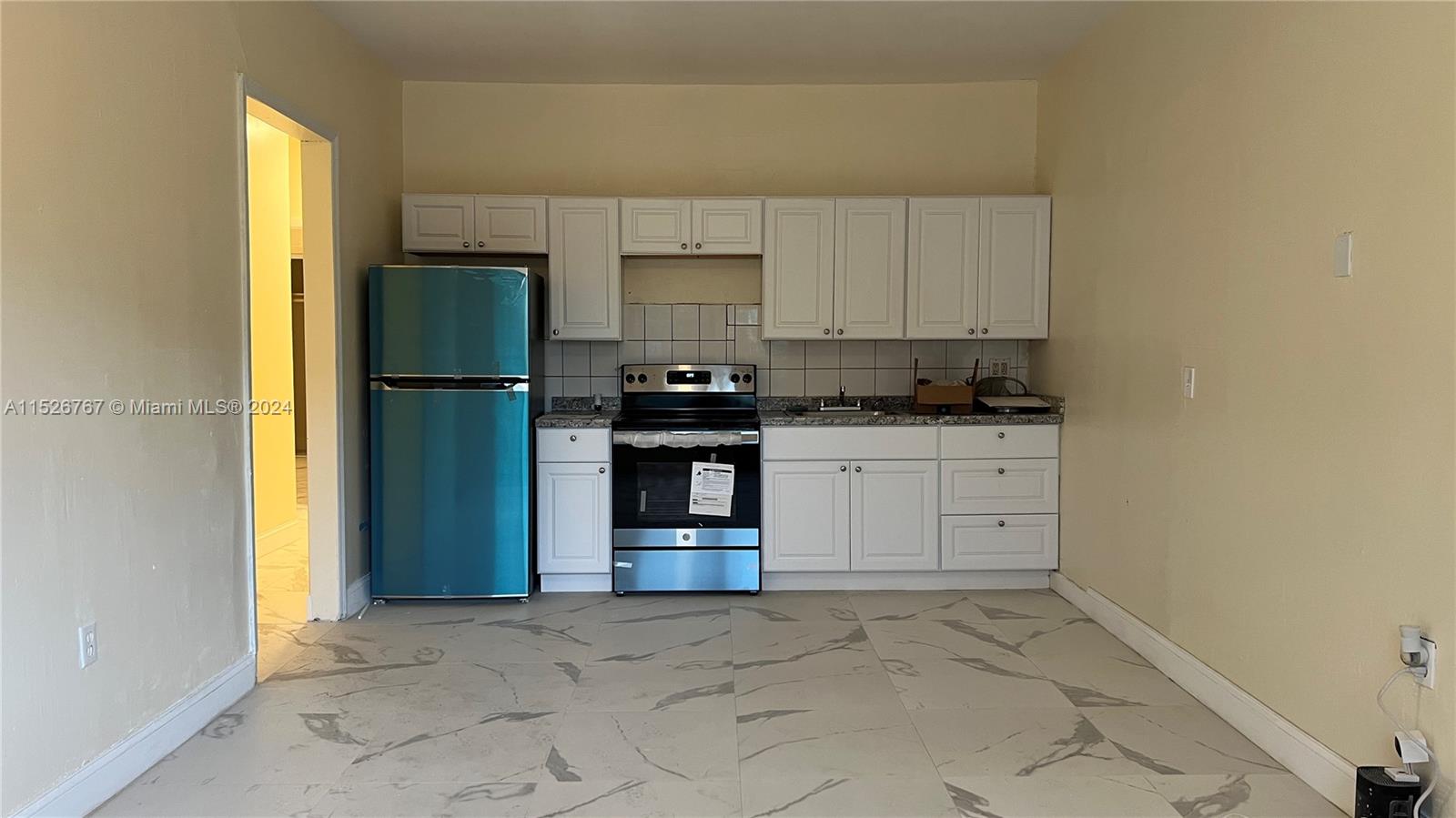 a kitchen with a sink a refrigerator and cabinets