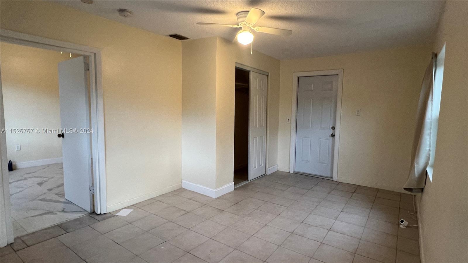 2168 Northwest 28th Street, Unit 1 Miami, FL 33142 - Photo 10 of 13 an empty room with fan and entrance