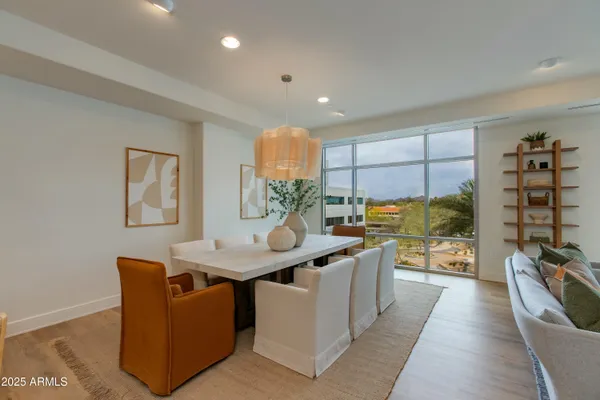 a living room with stainless steel appliances furniture a rug and a kitchen view