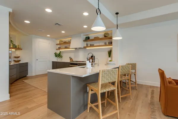 a kitchen with stainless steel appliances kitchen island granite countertop a table chairs and a refrigerator