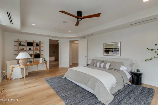 a bedroom with a large bed and a chandelier