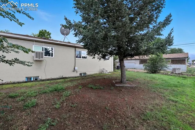 a white house that has a tree in front of it