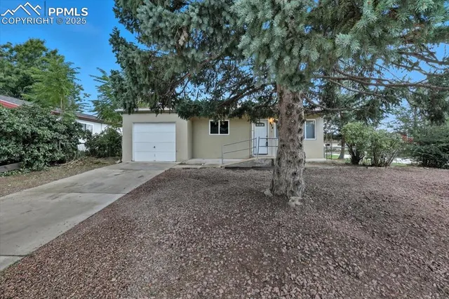a view of a house with yard and a tree