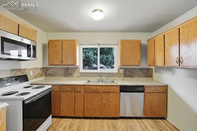 a kitchen with a sink stove top oven and cabinets