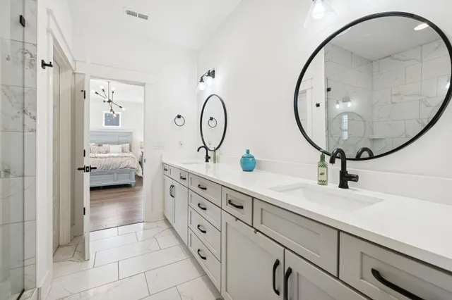 a en suite bathroom with a double vanity sink and a mirror