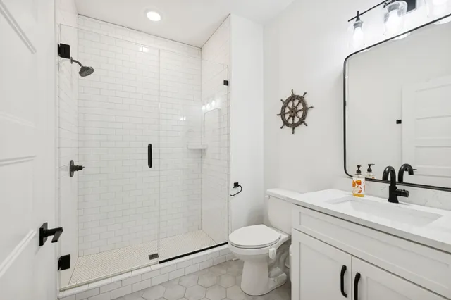 a bathroom with a sink a toilet and shower