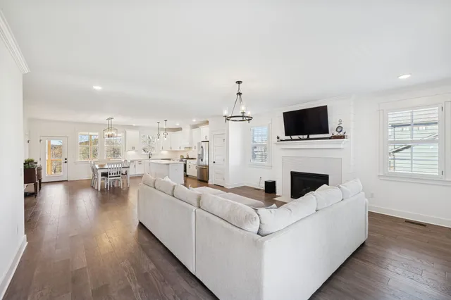 a living room with furniture a fireplace and a flat screen tv