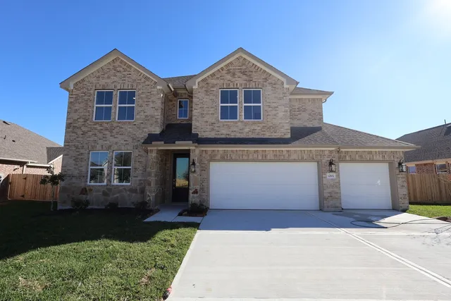 a front view of a house with a garden and garage