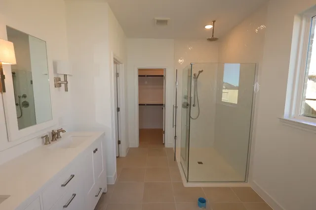 a bathroom with a double vanity sink mirror and shower