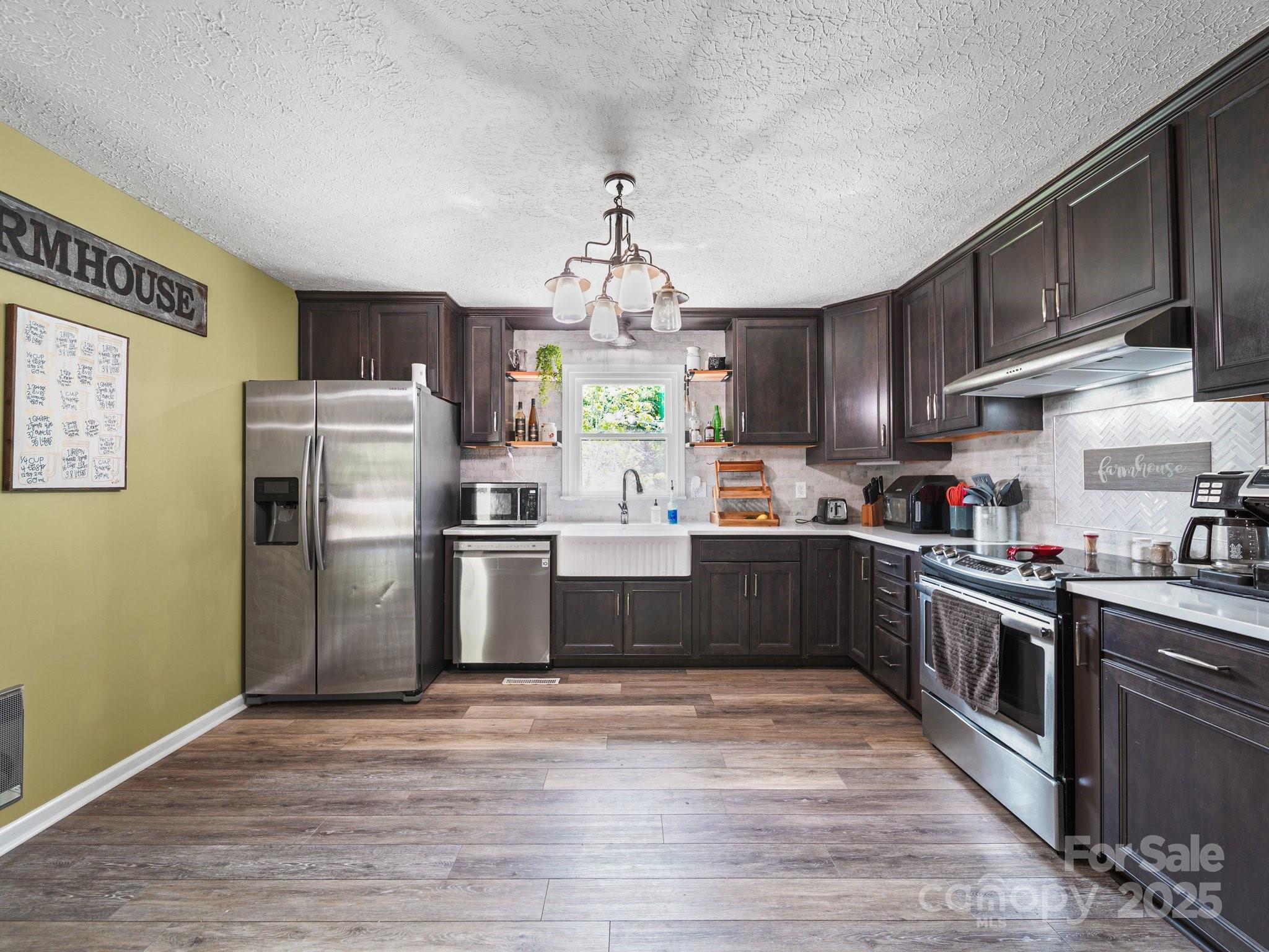 4615 Lockhart Road Sharon, SC 29742 - Photo 4 of 18 a large kitchen with stainless steel appliances granite countertop a stove top oven a refrigerator and a sink