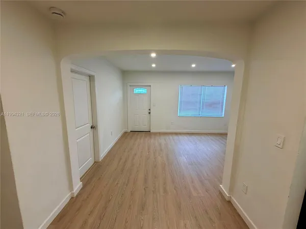 a view of a room with wooden floor and window
