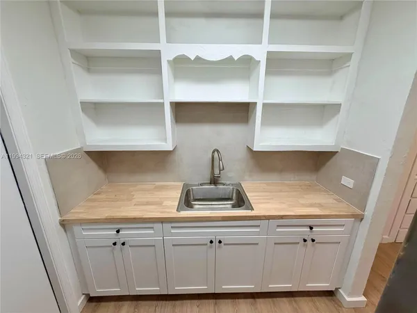 a kitchen with white cabinets and a sink
