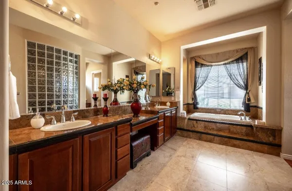 a bathroom with a tub sink and mirror
